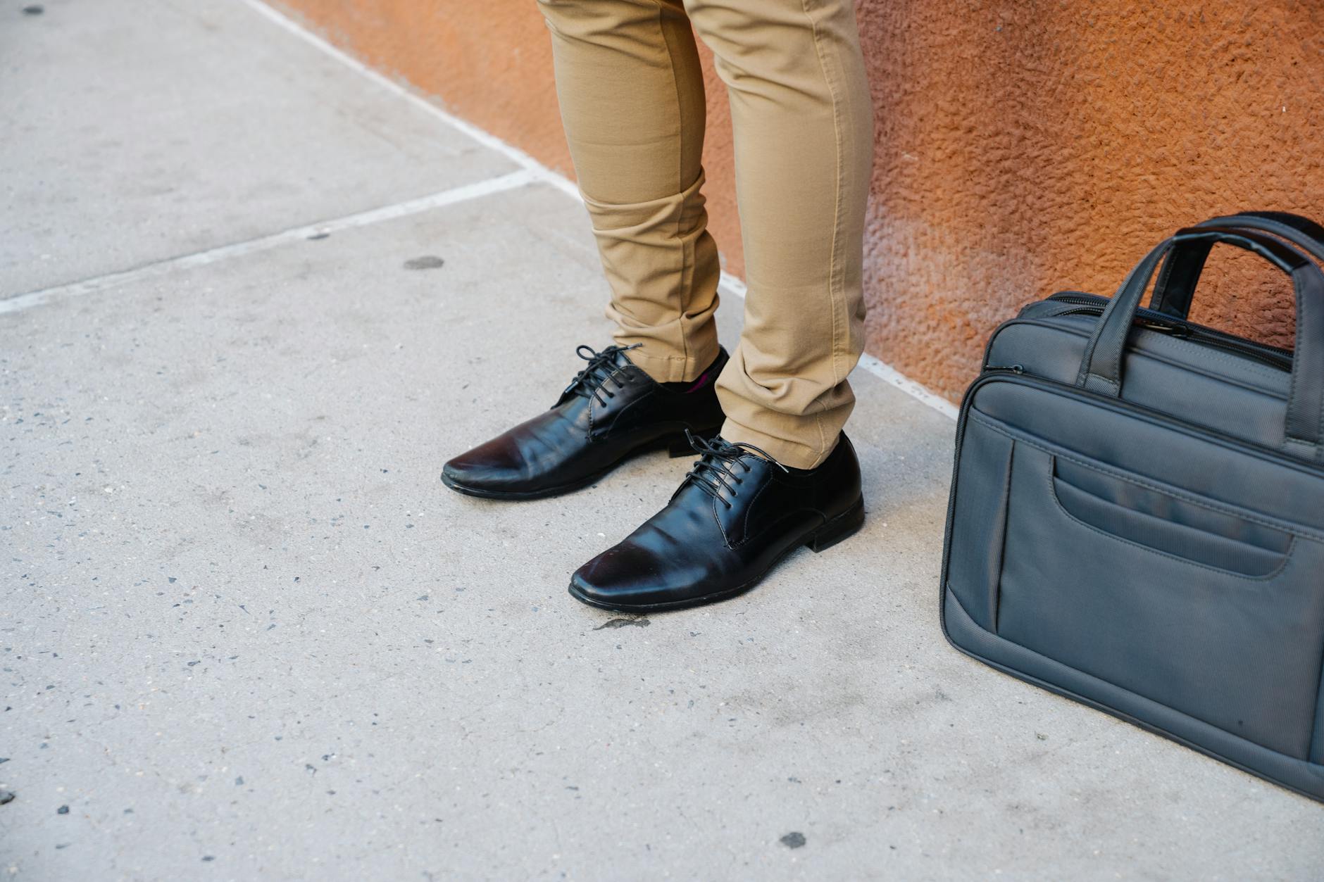 person in khaki pants and black leather shoes